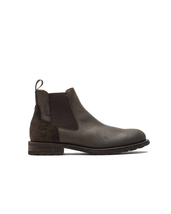 A brown leather Chelsea boot with a suede accent on the heel and elastic side panels. The boot has a pull tab and a chunky sole, and its shown against a white background.