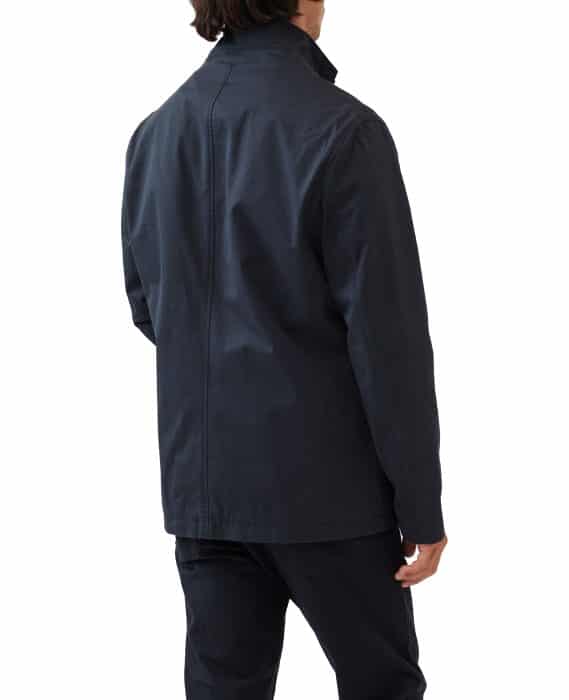 Person wearing a dark jacket and pants is seen from the back against a white background.