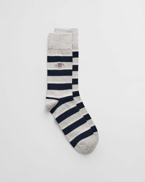 A pair of knee-high socks with a pattern of alternating black and light gray stripes. There is a small embroidered shield logo on the upper part of each sock. The socks are laid flat on a light background.