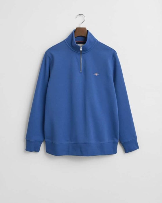 Blue quarter-zip sweater on a wooden hanger against a white background. The sweater features a small embroidered logo on the left chest and has ribbed cuffs.