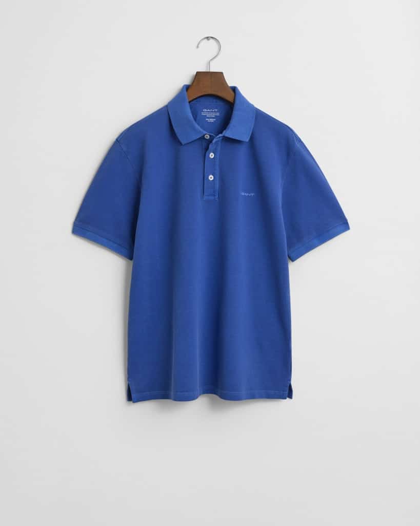 A blue polo shirt on a hanger against a white background. The shirt features a traditional collar, short sleeves, and three buttons on the placket.