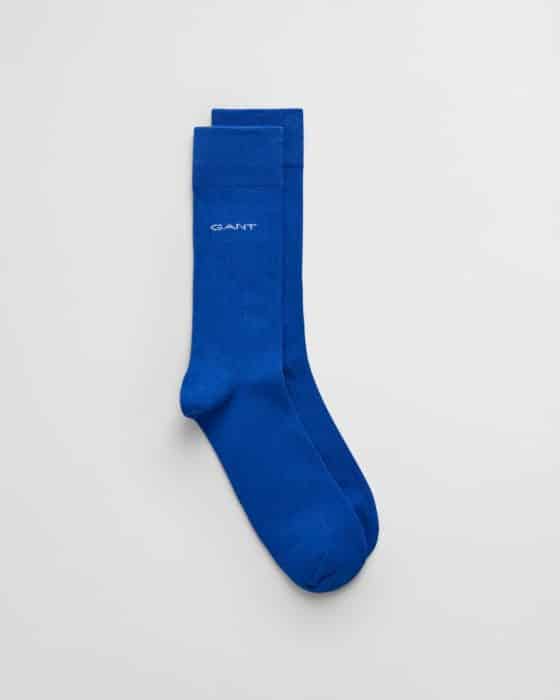 A pair of vibrant blue socks with GANT embroidered near the top, laid flat on a white background.