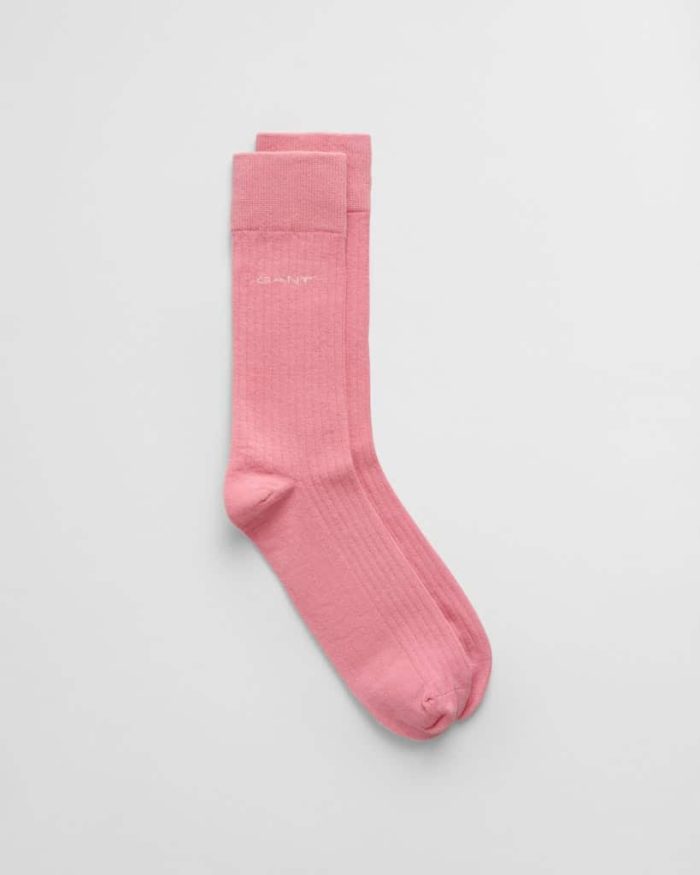 Pink knee-high socks laying flat against a white background, with a subtle ribbed texture and a small logo near the top.