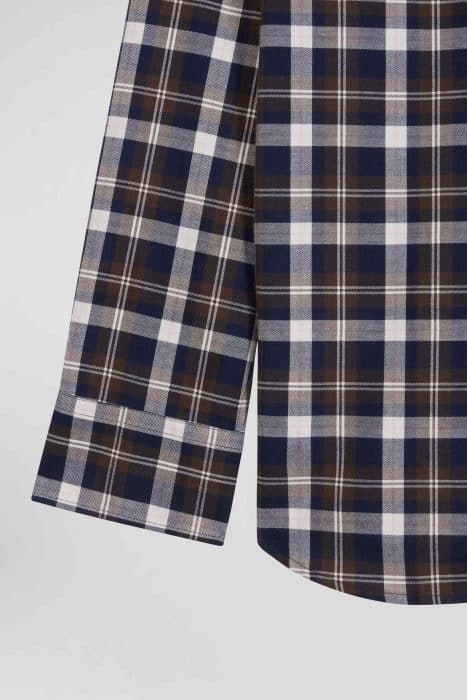 Close-up of a long-sleeve shirt with a plaid pattern in navy blue, brown, and white. The shirt is shown from the side, highlighting the cuff and the straight hem on a light gray background.