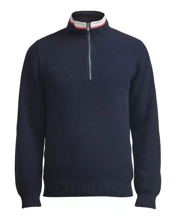 A dark blue, long-sleeved sweater with a textured pattern. It features a zip-up high collar with white and red trim. The zipper is half-open, adding a casual touch to the garment.