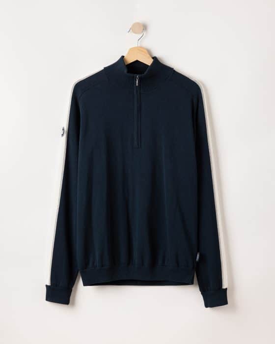 A navy blue pullover sweater with a half-zip front, hanging on a wooden hanger. The sweater features cream-colored stripes along the sleeves and a small logo patch on one sleeve.