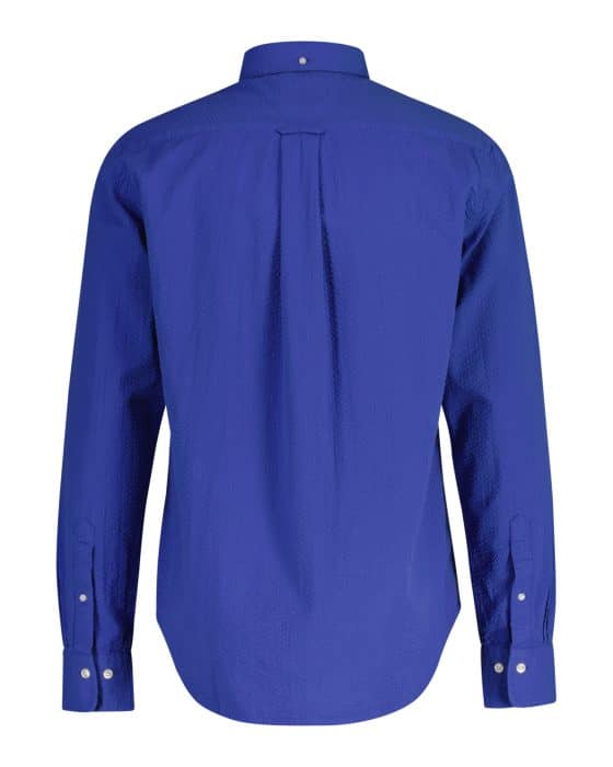A long-sleeved, button-up shirt in a vibrant blue color is shown from the back. It has a classic collar and buttoned cuffs. The fabric appears textured, and there is a centered pleat on the back.
