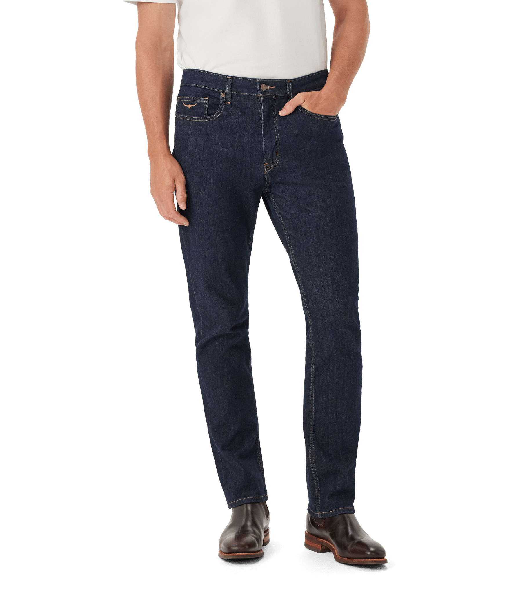 A person wearing a white shirt, dark blue slim-fit jeans, and brown boots stands with one hand in their pocket against a white background.