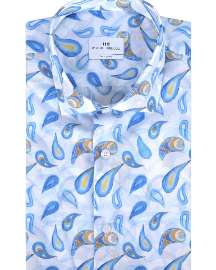 A folded, long-sleeve dress shirt with a light blue background and a colorful paisley pattern in blue, yellow, and orange. The shirt has a classic collar and white buttons, with a visible brand label inside the collar.