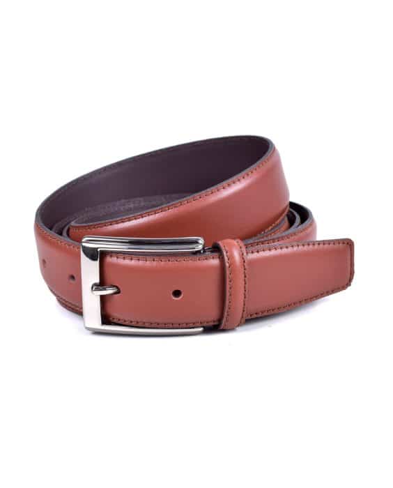 A coiled brown leather belt with a silver rectangular buckle, featuring stitching along the edges, displayed against a white background.
