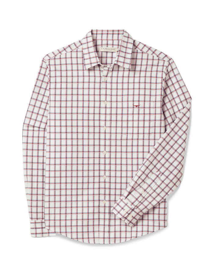 A long-sleeved, button-up dress shirt with a white background and a red and blue checkered pattern, displayed flat against a black background.
