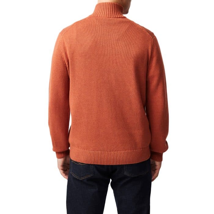A person wearing a burnt orange turtleneck sweater and dark blue jeans, shown from the back against a white background.