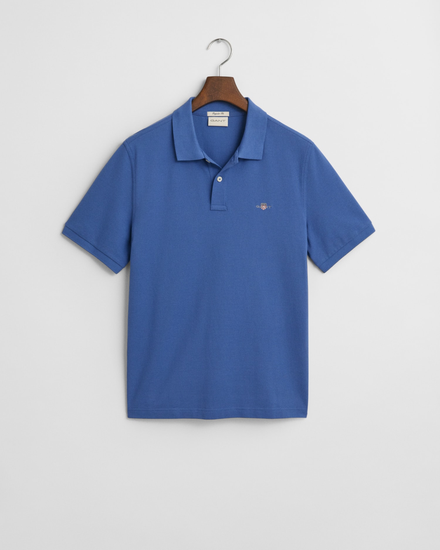 A blue short-sleeve polo shirt with a collar and buttons, displayed on a hanger against a white background. The shirt has a small embroidered logo on the left chest.