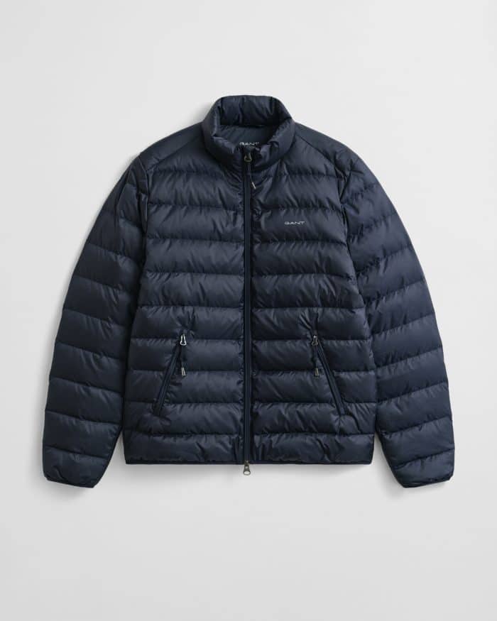 A navy blue puffer jacket with horizontal quilting, a stand-up collar, and two zippered side pockets, displayed on a plain white background.