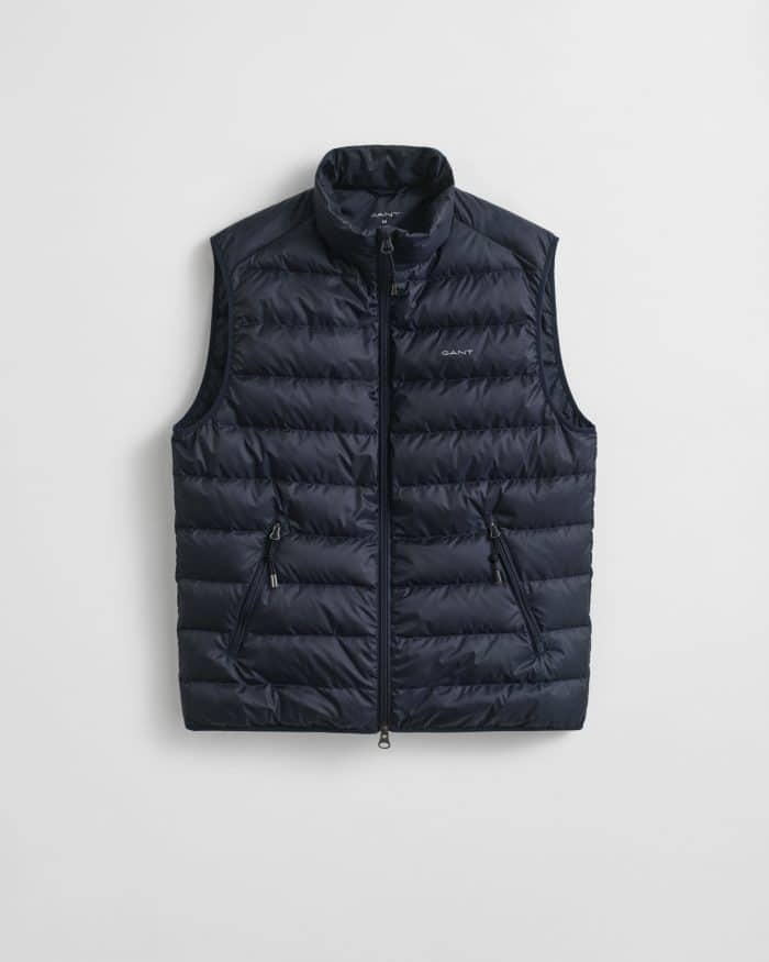 A sleeveless, navy blue puffer vest with a high collar, front zipper, and two zippered side pockets, displayed against a plain white background.