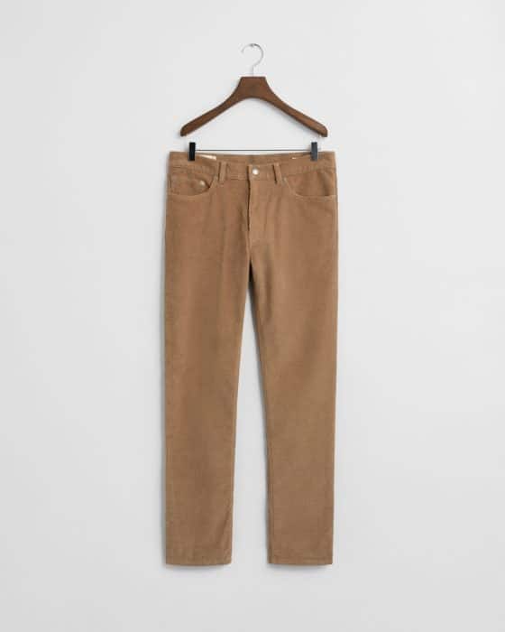 A pair of tan corduroy pants with front and back pockets hangs on a wooden hanger against a plain white background.