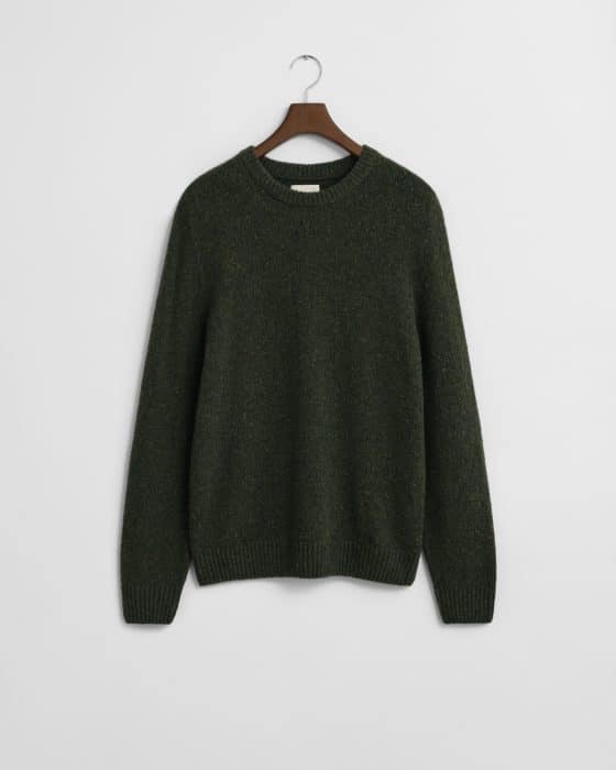 A dark green knit sweater with long sleeves and a round neckline, hanging on a wooden hanger against a plain white background.
