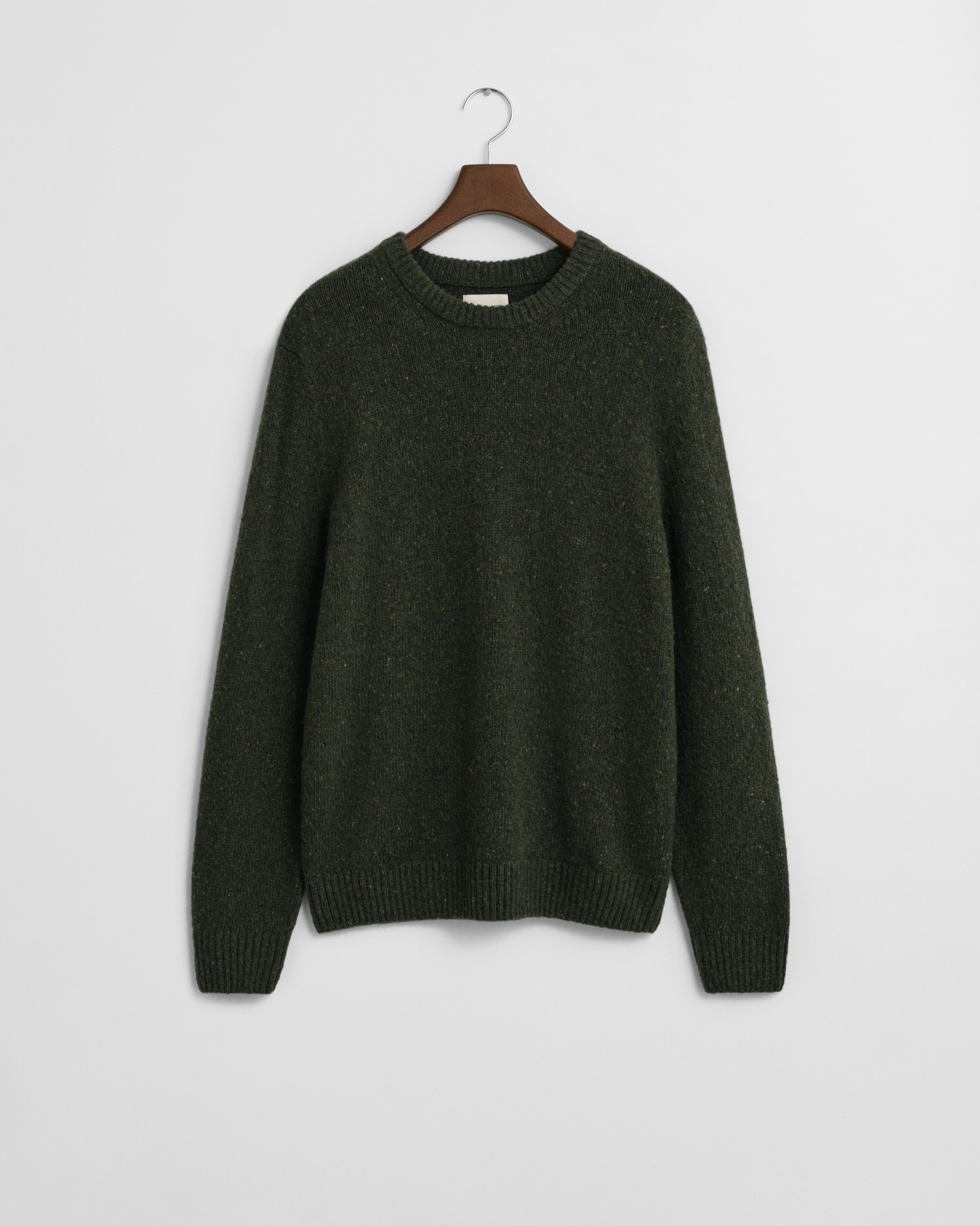 A dark green knit sweater with long sleeves and a round neckline, hanging on a wooden hanger against a plain white background.