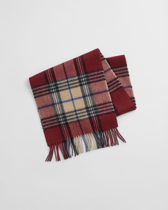 A folded, wool scarf with a red, beige, and black plaid pattern, featuring fringe on both ends, displayed on a white background.