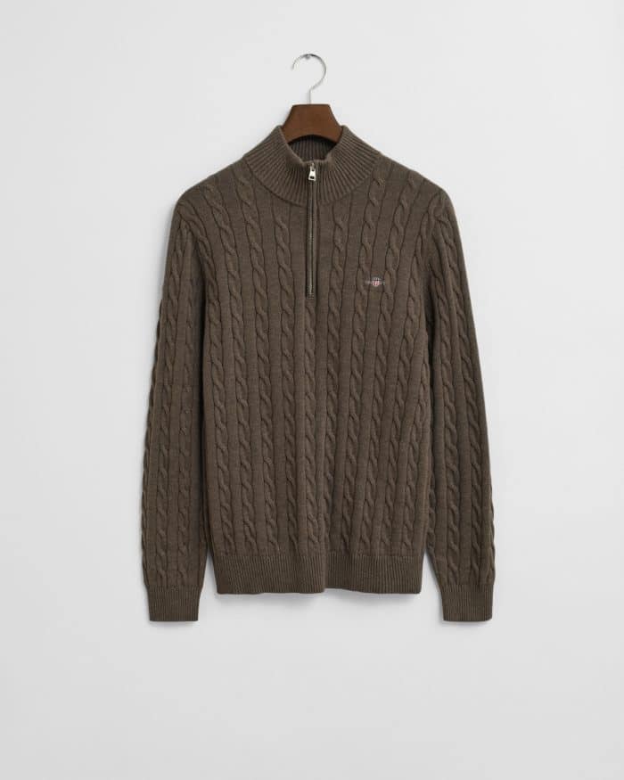 A brown cable-knit sweater with a half-zip collar, hanging on a wooden hanger against a plain white background.
