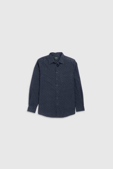 A long-sleeved, navy blue button-up shirt with a small white polka dot pattern, displayed against a plain light gray background.
