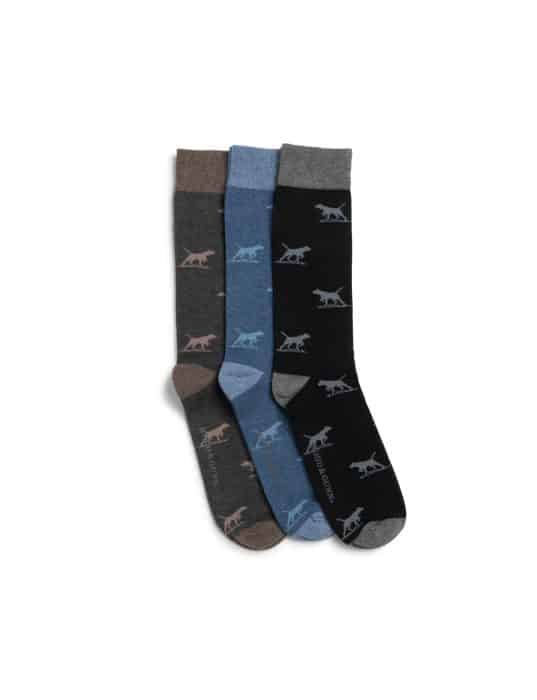Three pairs of crew socks in brown, blue, and black, each featuring a repeating dog silhouette pattern and contrasting heel and toe colors, displayed side by side on a white background.