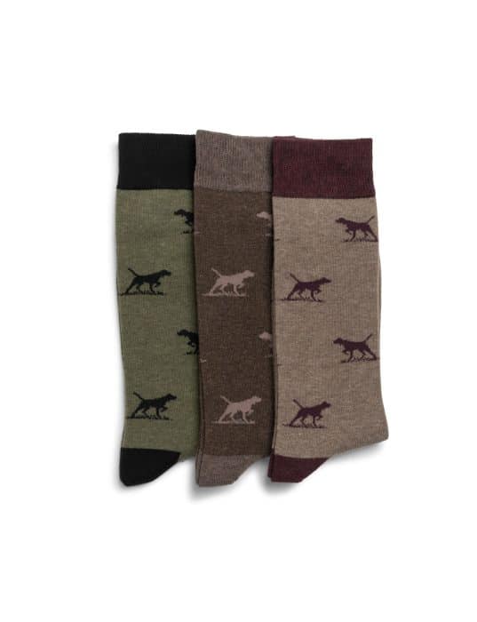 Three pairs of socks in green, brown, and beige, each featuring a dinosaur silhouette pattern, laid flat side by side on a white background.