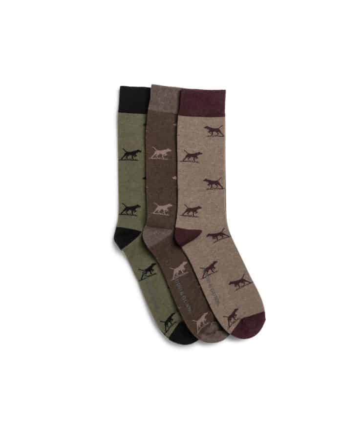 Three pairs of crew socks in green, brown, and beige, each featuring a repeated pattern of dark-colored dogs in a pointing pose. The socks are neatly arranged and overlapping on a white background.