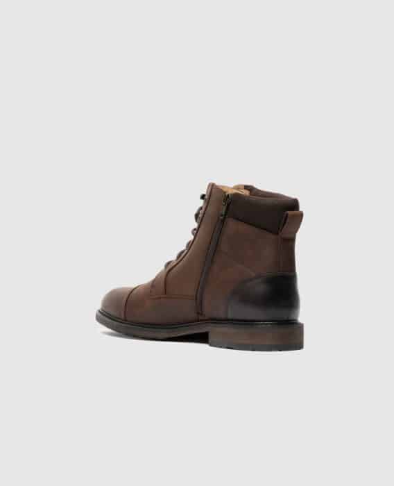 A brown leather lace-up boot with a side zipper and black heel, seen from a rear side angle against a plain light gray background.