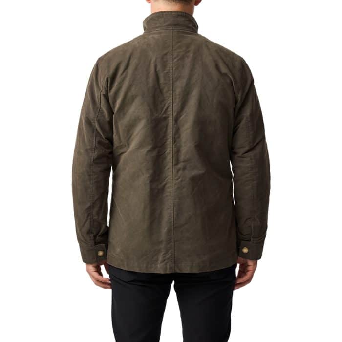 A person is shown from the back wearing an olive green jacket with a high collar and buttoned cuffs, paired with black pants. The background is plain white.