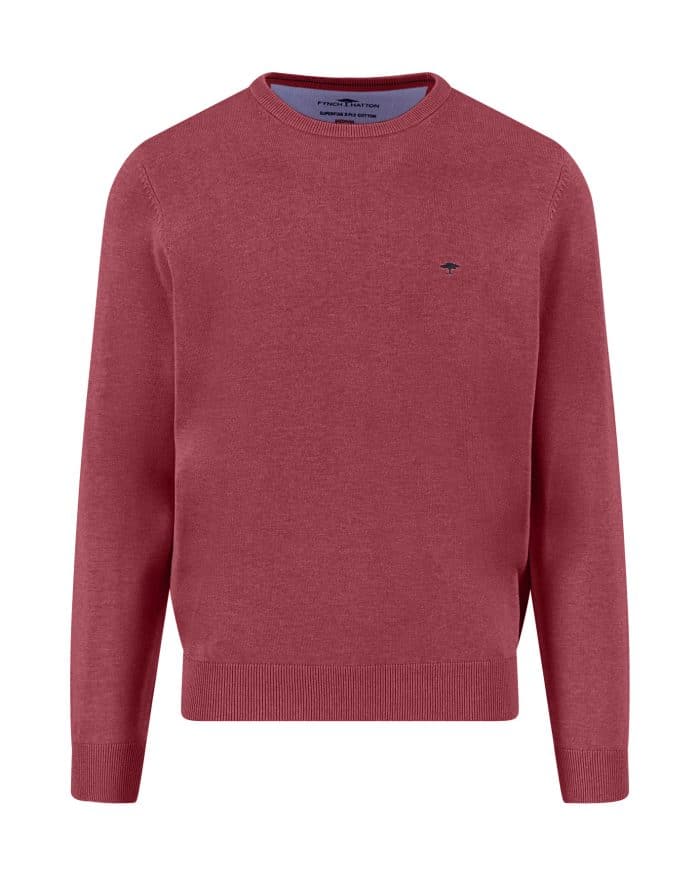 A plain, long-sleeved, crew neck sweater in a muted red color with a small, dark embroidered logo on the left chest. The sweater has ribbed cuffs, hem, and neckline.