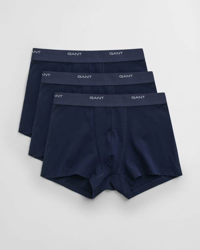 Three pairs of navy blue mens boxer briefs with elastic waistbands featuring the brand name GANT in white text, arranged in a slightly overlapping, fanned-out pattern on a white background.