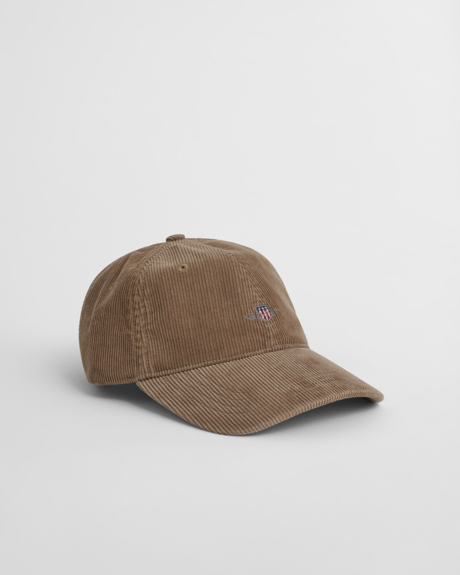 A brown corduroy baseball cap with a curved brim and a small embroidered logo on the front, displayed against a plain white background.
