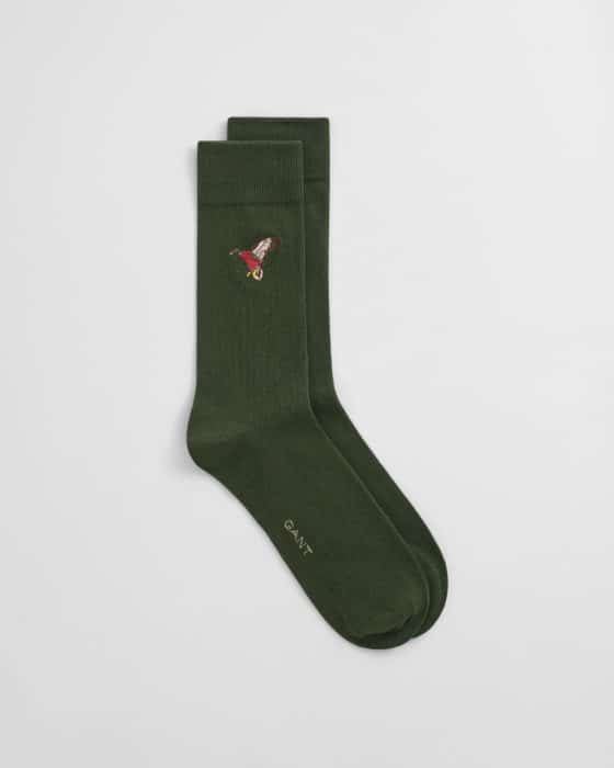 A pair of dark green socks with a small embroidered mushroom design near the top and the word GANT printed near the toe on a plain white background.