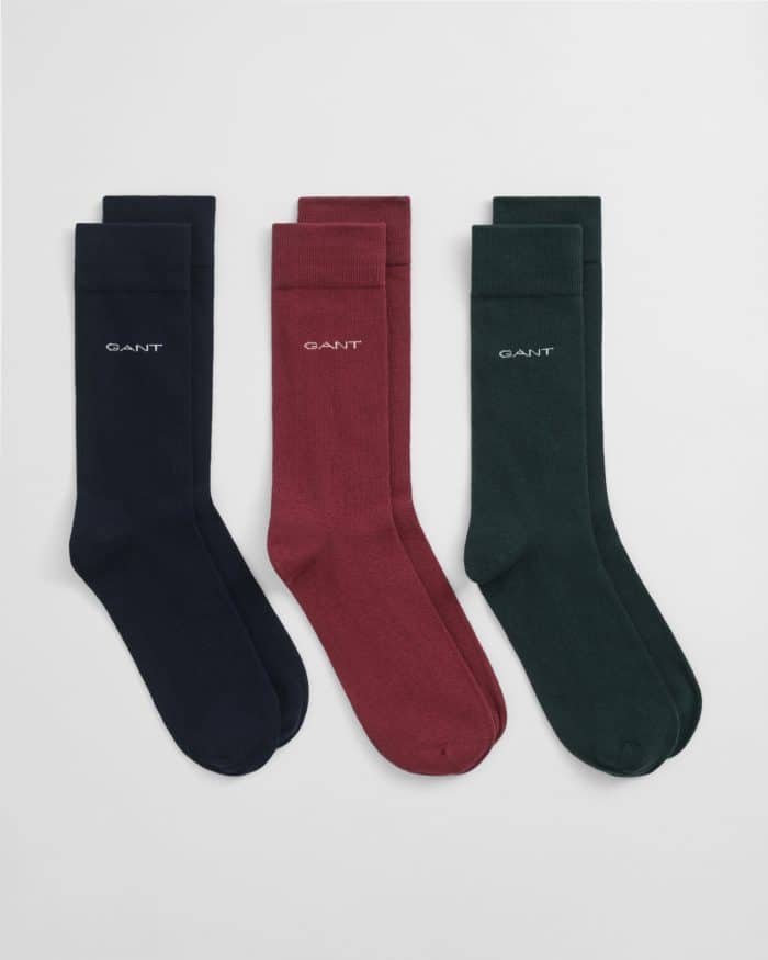 Three pairs of GANT socks in navy blue, burgundy, and dark green, each with the brand name embroidered near the top, displayed side by side on a white background.