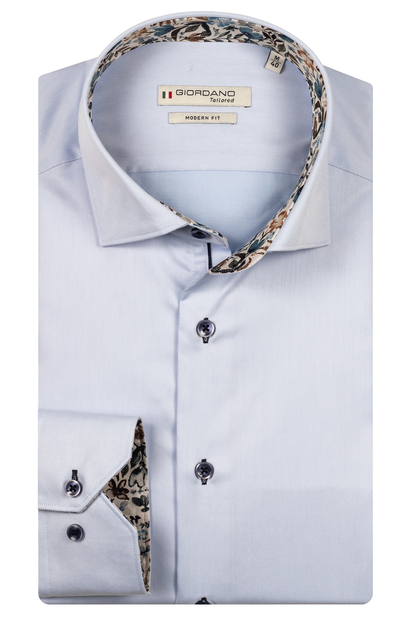 A light blue long-sleeve dress shirt with a modern fit, folded neatly. The inner collar and cuffs feature a floral pattern. The shirt has dark buttons and a Giordano Tailored label on the inside collar.