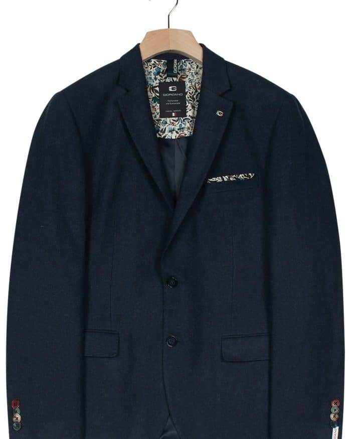A dark navy blue blazer on a wooden hanger, featuring notch lapels, two buttons, front pockets, and a patterned pocket square in the chest pocket.