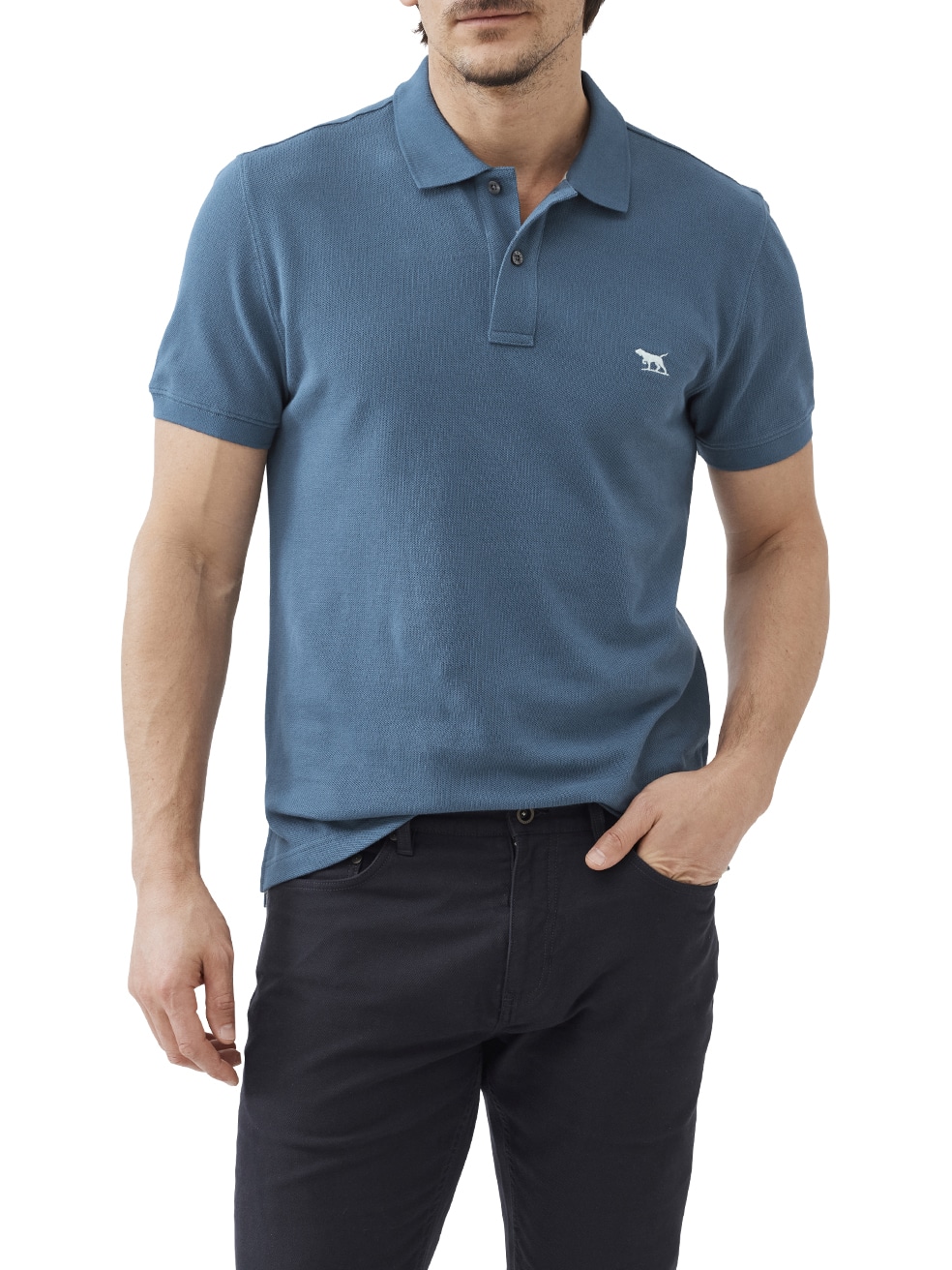 A man wearing a teal short-sleeve polo shirt with a small embroidered logo on the chest and dark pants, standing with one hand in his pocket against a white background.