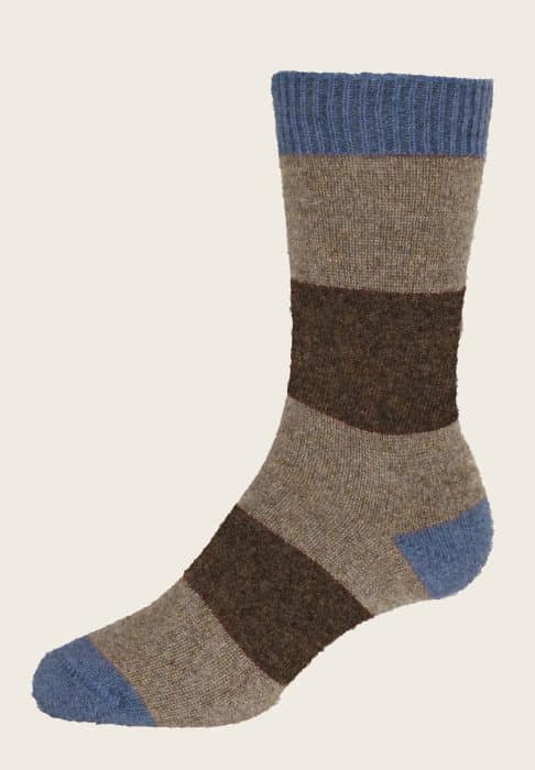 A wool sock with wide horizontal stripes in tan and dark brown, featuring blue ribbed cuffs, toe, and heel, displayed on a plain light background.