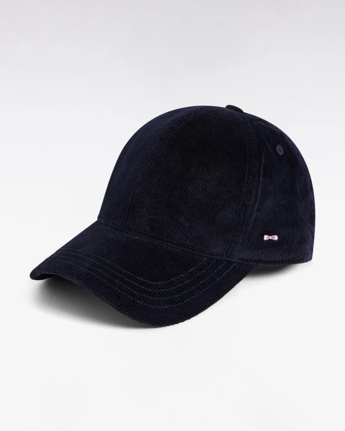 A navy blue corduroy baseball cap with a curved brim, displayed against a plain white background. There is a small metallic detail on the side of the cap.
