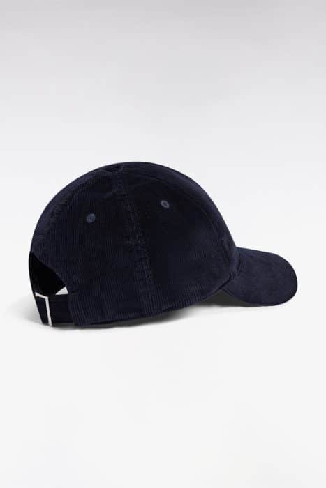 A navy blue corduroy baseball cap with a curved brim, viewed from the back and side, featuring an adjustable strap with a silver buckle. The background is plain white.