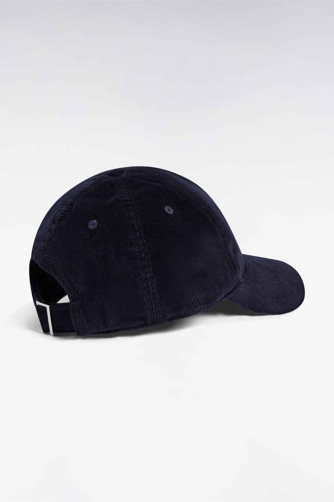A navy blue corduroy baseball cap with a curved brim, viewed from the back and side, featuring an adjustable strap with a silver buckle. The background is plain white.
