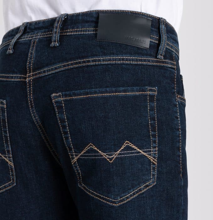 Close-up of the back of a person wearing dark blue jeans with orange stitching, two back pockets with V-shaped designs, and a black leather patch near the waistband.