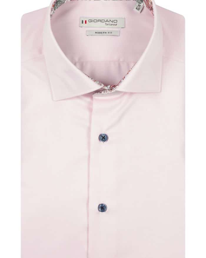 A neatly folded, light pink dress shirt with dark buttons, a pointed collar, and floral-patterned fabric inside the collar. The label reads Giordano Tailored Modern Fit.