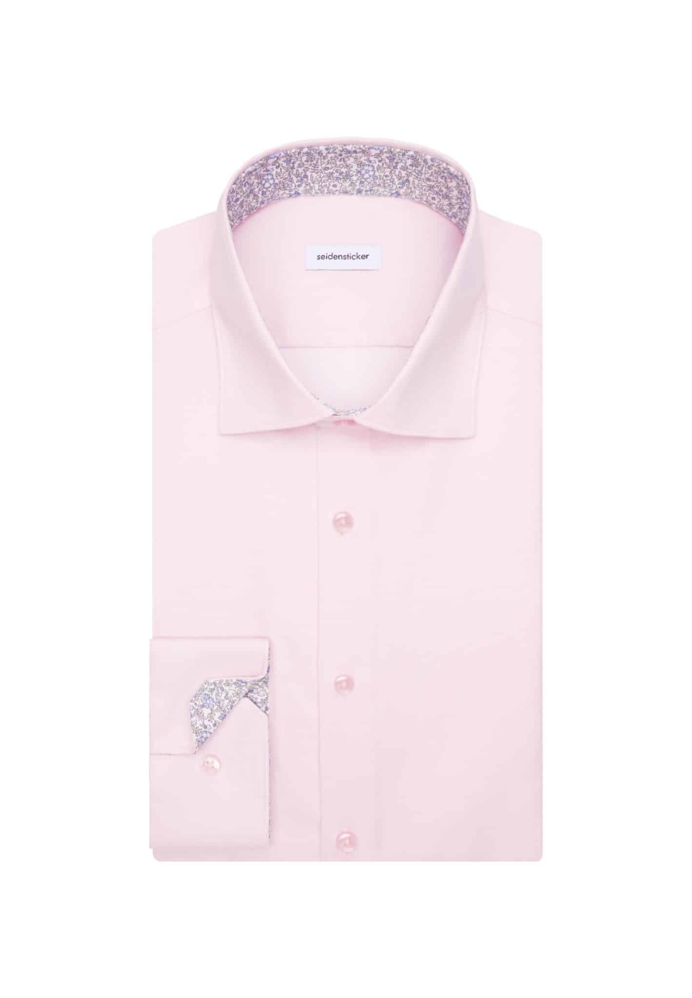 A neatly folded light pink dress shirt with floral-patterned fabric visible inside the collar and cuffs, displayed on a white background.