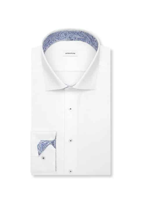 A neatly folded white dress shirt with a blue paisley pattern on the inner collar and cuff. The shirt is buttoned and displayed on a white background.