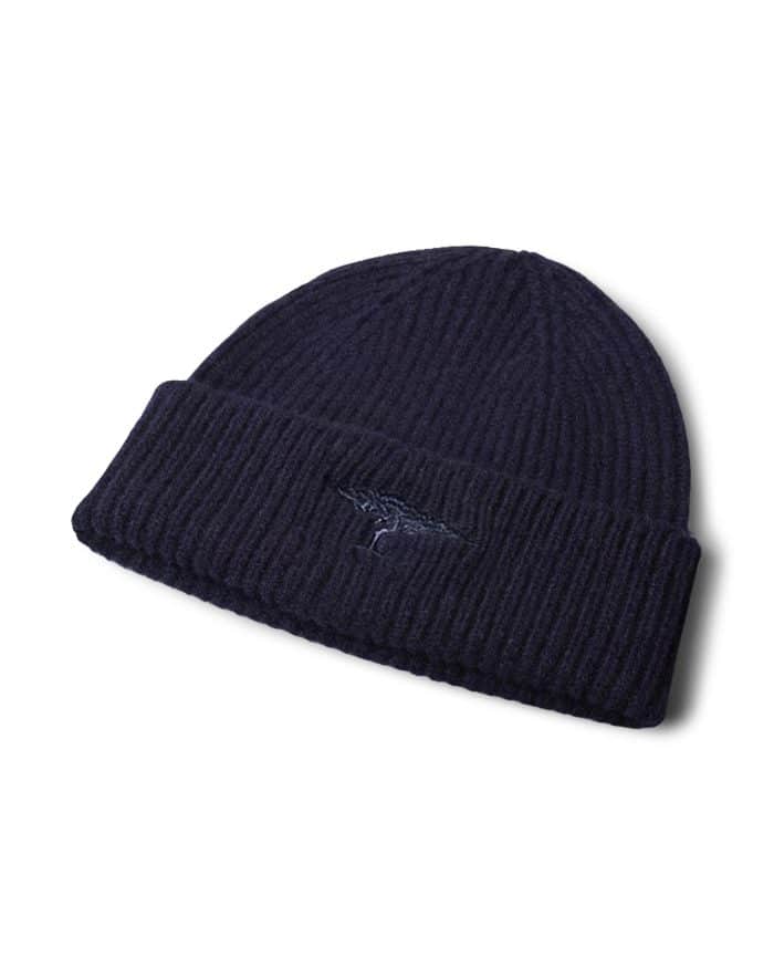 A navy blue ribbed knit beanie with a folded brim and an embroidered logo on the front, displayed on a white background.