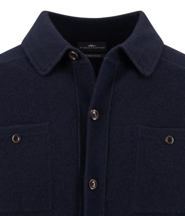 Close-up of a dark navy wool button-up shirt with two chest pockets and brown buttons, featuring a collar and visible stitching details.