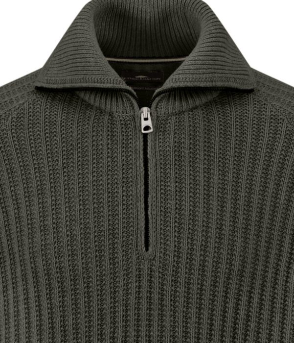 A close-up of a ribbed, dark green quarter-zip jumper with a folded collar and a silver zip partially unzipped.