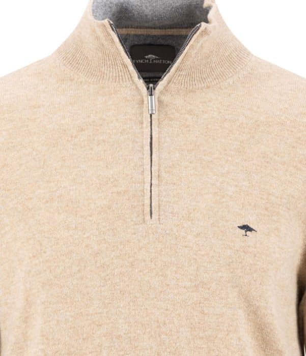 Beige quarter-zip jumper with a small embroidered logo of a bird on the left chest. The collar is ribbed and folded down, and the zip is partially open. The fabric appears soft and cosy.